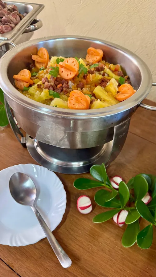 Mesa decorada com buffet de churrasco, saladas e pães